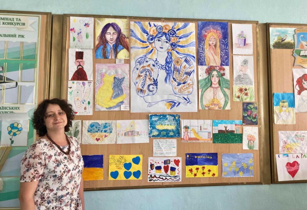Olena with some of the artwork created by her students, many of which depict a desire for peace
