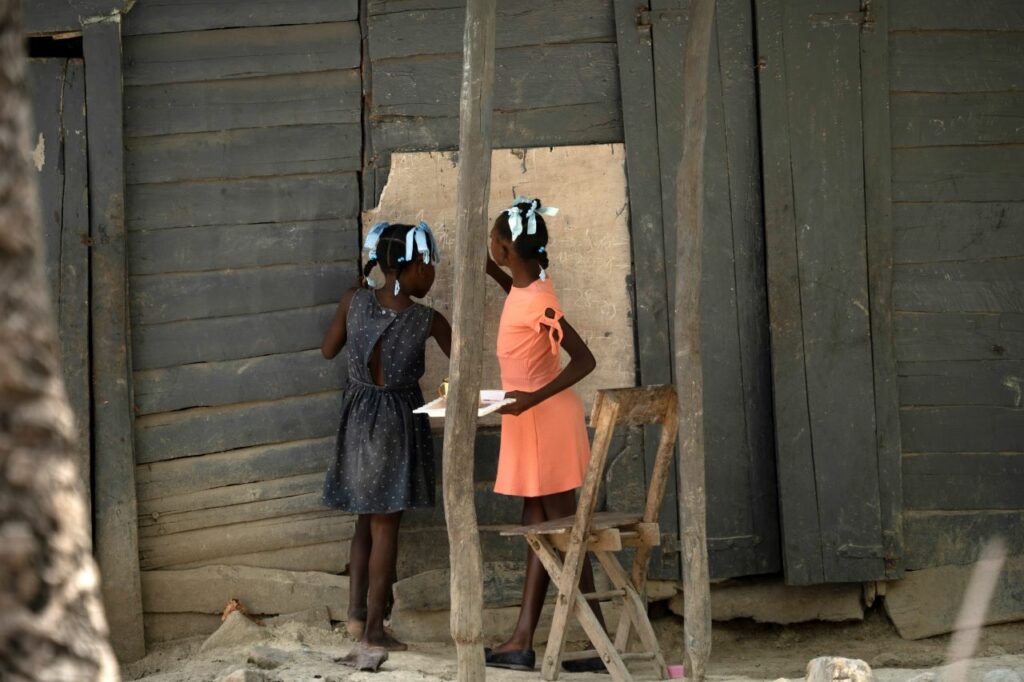 Girls write on blackboard near to Chedeline's house