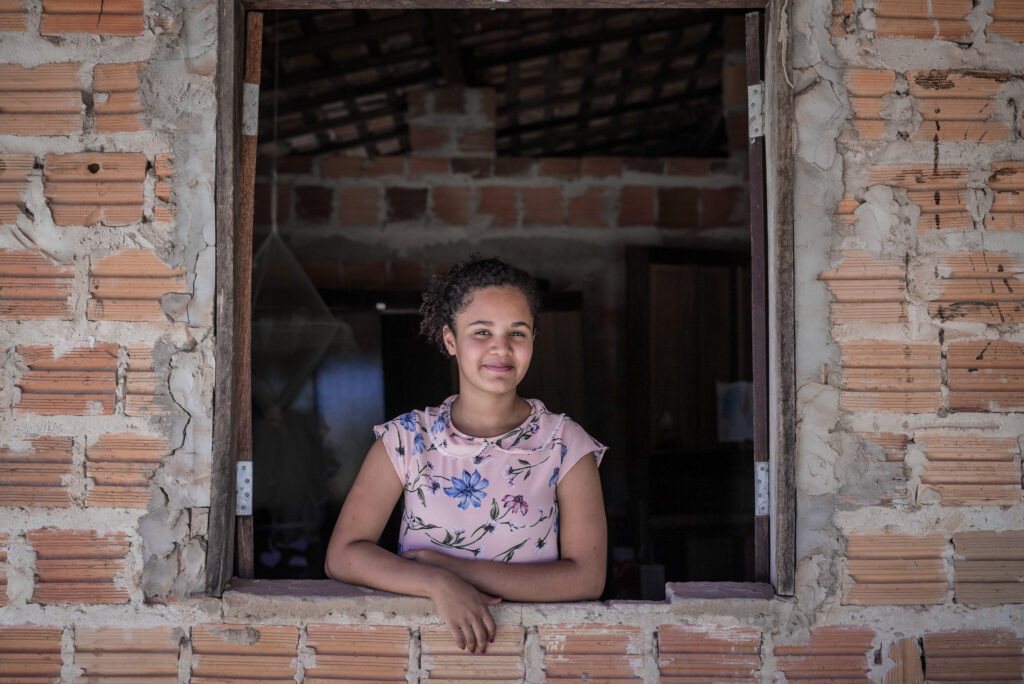 Sanmya, looks out the window in her home in Codo, Brazil