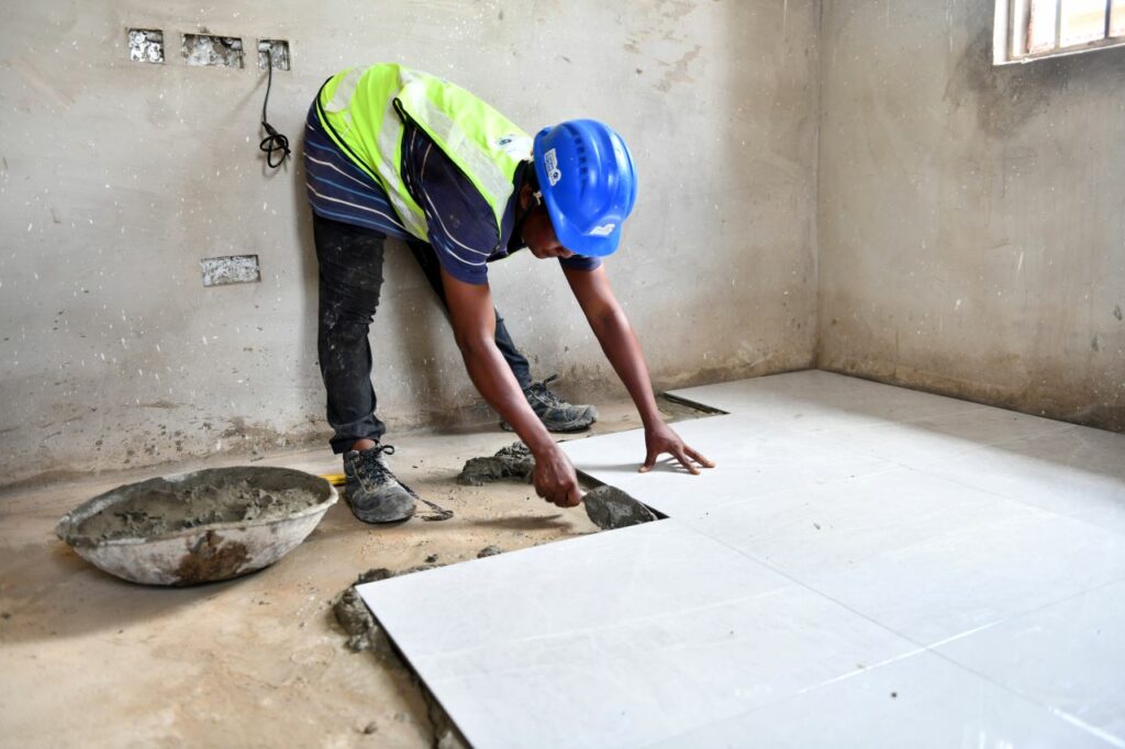 Ayisha laying tiles